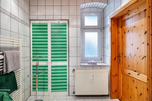 a bathroom with green shutter doors and a window at Ferienwohnung Bernoth in Erfurt