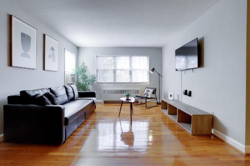 a living room with a couch and a tv at Stylish Corporate Apartment in Alexandria in Alexandria