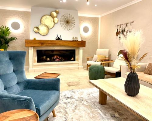 a living room with a blue couch and a fireplace at Hotel Particulier Les Rêveries du CLOS derrière St Jean Vignes &Spa Adult Only in Pommard