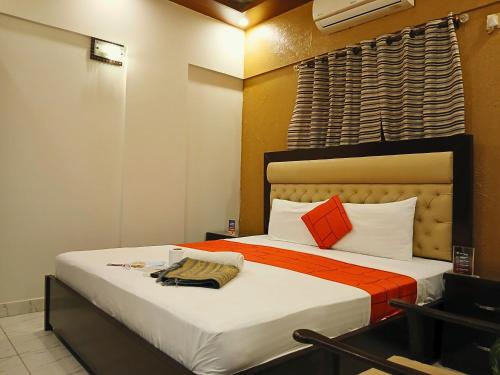 a bedroom with a bed with orange and white pillows at Hometown Apartments & Rooms in Karachi