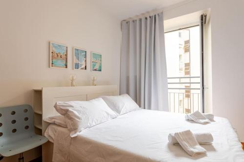 a white bedroom with a bed and a window at Parco Urbano - Tranquillità a due passi dal centro in Trieste