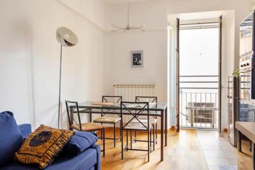 a living room with a blue couch and a table and chairs at Parco Urbano - Tranquillità a due passi dal centro in Trieste
