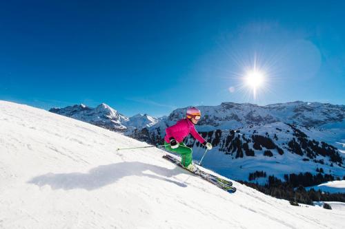 a person is skiing down a snow covered slope at Bellevue Parkhotel & Spa - Relais & Châteaux in Adelboden