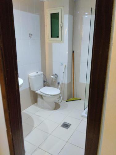 a bathroom with a toilet and a glass shower at فندق الخلفاء الفيصلية in Makkah
