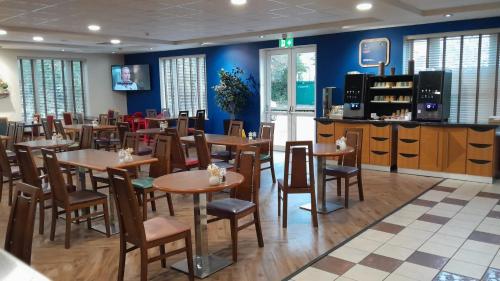 a dining room with tables and chairs and blue walls at Holiday Inn Express Poole by IHG in Poole