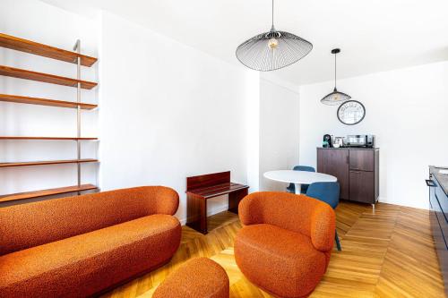 un salon avec deux chaises orange et une table dans l'établissement Guestready - Tastefully decorated studio for 2, à Paris
