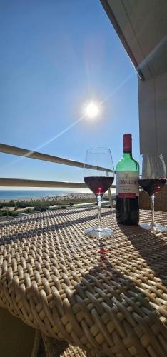 a bottle of wine and two glasses on a table at Surforama Apartment Meerblick am Südstrand in Fehmarn
