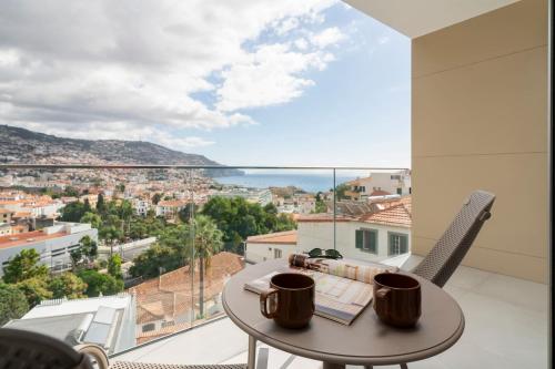 a balcony with a table and a view of the city at Maravilhas II by An Island Apart in Funchal