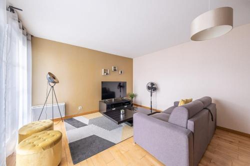 un soggiorno con un divano e una TV di S4 Disney Family a Serris