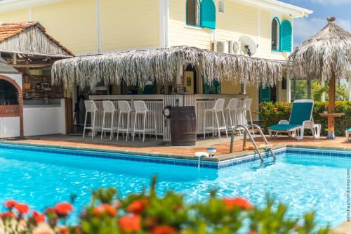 a swimming pool with chairs and a house at Domaine de l'Anse Simon - Piscine - 8 chambres in Le Vauclin