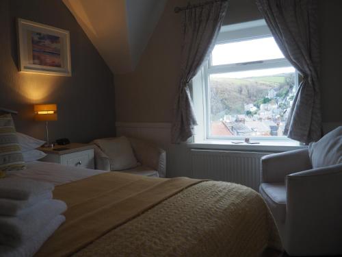 a hotel room with a bed and a window at South View Guest House in Lynton