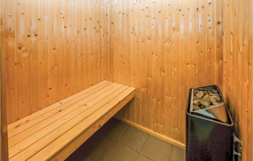 a wooden sauna with a bench and a trash can at Holiday Home Harbokobbel in Asserballeskov