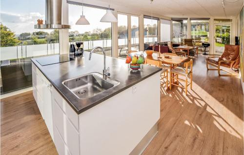 a kitchen with a sink and a living room at Holiday Home Harbokobbel in Asserballeskov