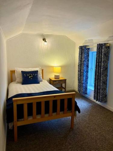 a bedroom with a bed and a window at Miners Cottage in Snowdonia in Blaenau-Ffestiniog