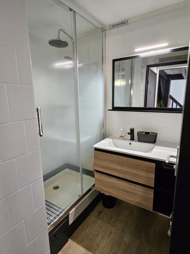 une salle de bain avec une douche en verre et un lavabo dans l'établissement Jolie maison de vacances rénovée toute climatisée 6 couchages, 2 chambres mezzanine 100m de la plage residence LE VILLAGE DE LA MER LRVM88, à Portiragnes