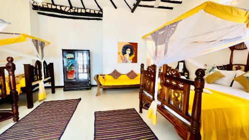 a bedroom with two beds and a yellow couch at Z-Breeze Zanzibar in Kiwengwa