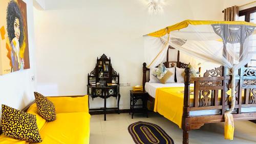 a bedroom with a bed and a couch at Z-Breeze Zanzibar in Kiwengwa