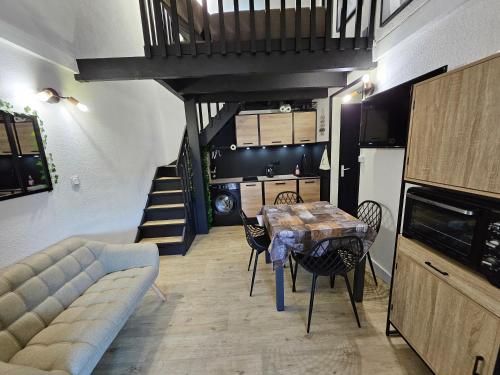 un salon avec une table et des chaises et un escalier dans l'établissement Jolie maison de vacances rénovée toute climatisée 6 couchages, 2 chambres mezzanine 100m de la plage residence LE VILLAGE DE LA MER LRVM88, à Portiragnes