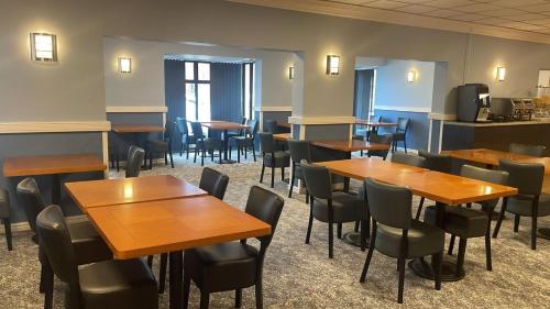 a dining room with wooden tables and chairs at Britannia Hotel Wigan in Standish