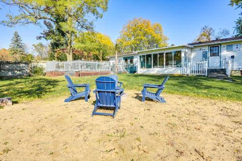 two blue chairs and a table in a yard at Sand Lake Retreat Canal Access and Large Yard! in Tipton