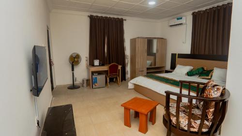 a bedroom with a bed and a desk and a television at The Luxe Apartment in Lagos