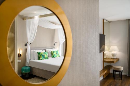 a hotel room with a bed and a mirror at Mövenpick Balaland Resort Lake Balaton in Szántód