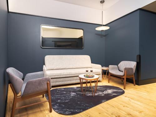 a living room with a couch and two chairs and a table at Axis Porto Club Aliados in Porto