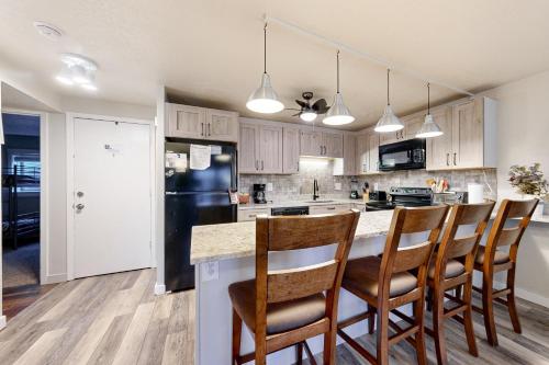 a kitchen with white cabinets and a black refrigerator at Summit Serenity in Dillon