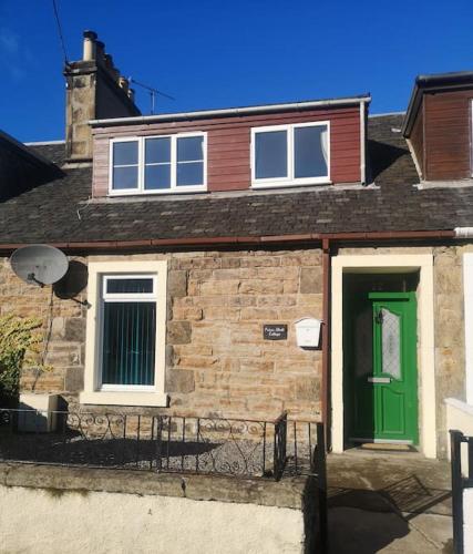 a brick house with a green door and windows at Friars Shott Cottage in Inverness