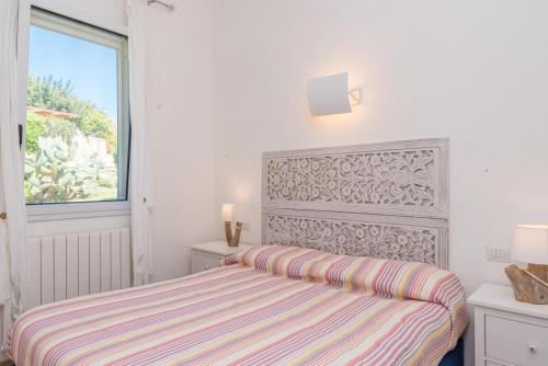 een witte slaapkamer met een bed en een raam bij Villa Asfodelo a Valle Dell' Erica in Valle Dell’Erica