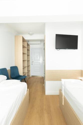 a hotel room with two beds and a flat screen tv at Millennia Hotel in Sofia