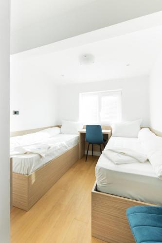 two beds in a room with a desk and a chair at Millennia Hotel in Sofia