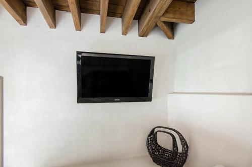 TV de pantalla plana en la pared con cesta de mimbre en Atelier Lumi - at lumicollection, en Miami