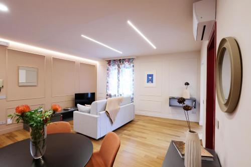 a living room with a white couch and a table at All'Angolo Deluxe Apartment in Alba