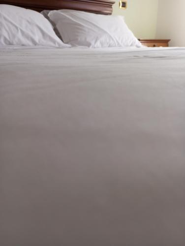a close up of a bed with white sheets at Regina Hotel Pollino in Morano Calabro