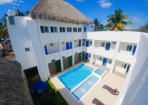 a house with a swimming pool in front of it at Hotel y Restaurante Playa Dorada in Monterrico
