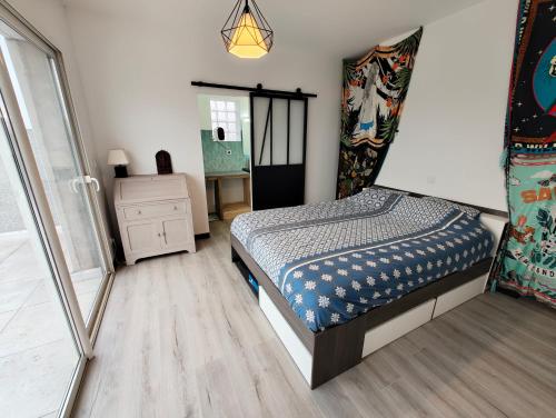 - une petite chambre avec un lit et une commode dans l'établissement Appartement Familial proche de Carcassonne, à Villemoustaussou