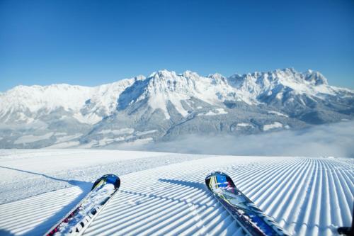 a pair of skis on top of a snow covered mountain at Das Alpin - Hotel Garni Guesthouse in Scheffau am Wilden Kaiser