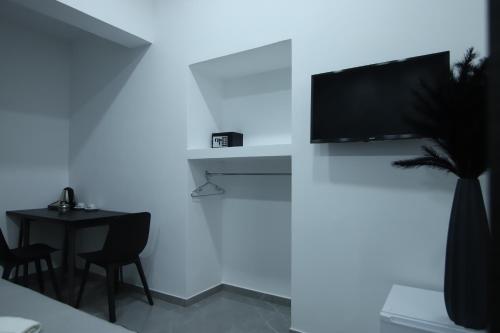a room with a table and a tv on a wall at Il Ritrovo Spa&Rooms in Naples