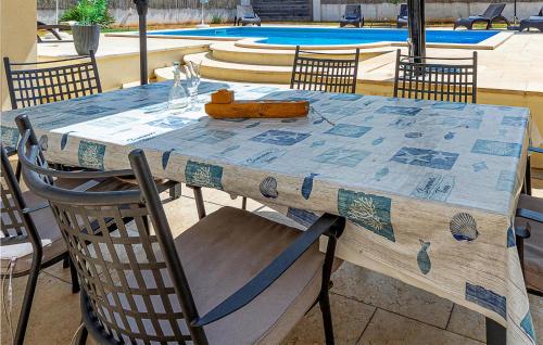 a table and chairs with a table and a pool at Awesome Home In Mihelici With Wifi in Buici