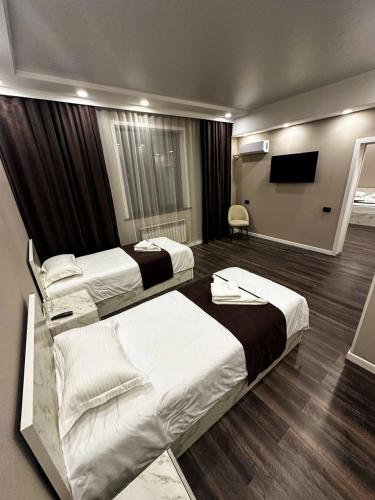 a hotel room with two beds and a flat screen tv at DOSTYK Hotel in Zyryanovsk