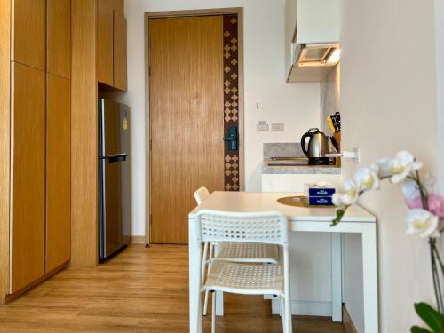 a small kitchen with a white table and chairs at Aristo 2 Phuket by RESAVA in Surin Beach
