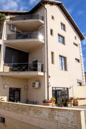 an apartment building with a balcony with plants at Casa Muntenească Alessandro in Piteşti