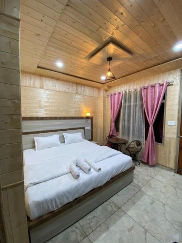 a bedroom with a large white bed with pink curtains at Scenic Village Stay near Kufri With Bonfire & Veg Meals-Alpine Crest Homestay Kufri in Theog