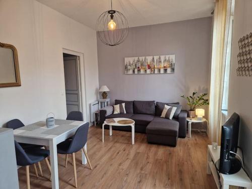 un salon avec un canapé et une table dans l'établissement Appartement cosy hypercentre, à Narbonne