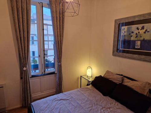 une chambre avec un lit et une fenêtre dans l'établissement Appartement cosy hypercentre, à Narbonne