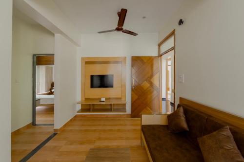 a living room with a couch and a flat screen tv at Lykke Suites- 2-min Drive to Colva Beach-By Goan Felicidade Hospitality PVT LTD in Colva