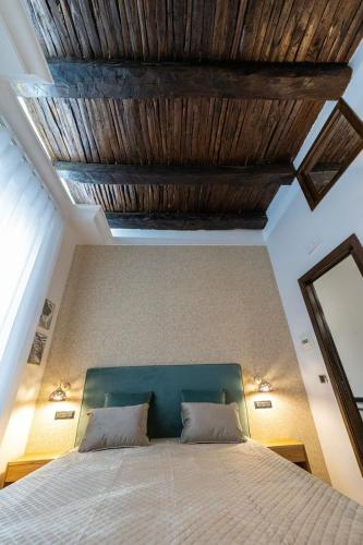 a bedroom with a bed with a wooden ceiling at B & B Boutique Epoca in Salerno