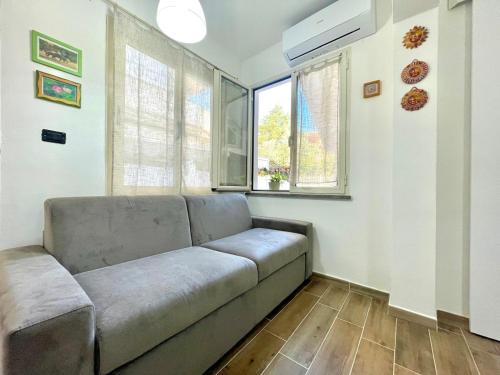 a living room with a couch and a window at Teddy House Apartments in Bari Sardo