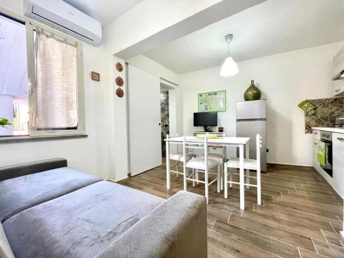 a room with a bed and a table and a kitchen at Teddy House Apartments in Bari Sardo